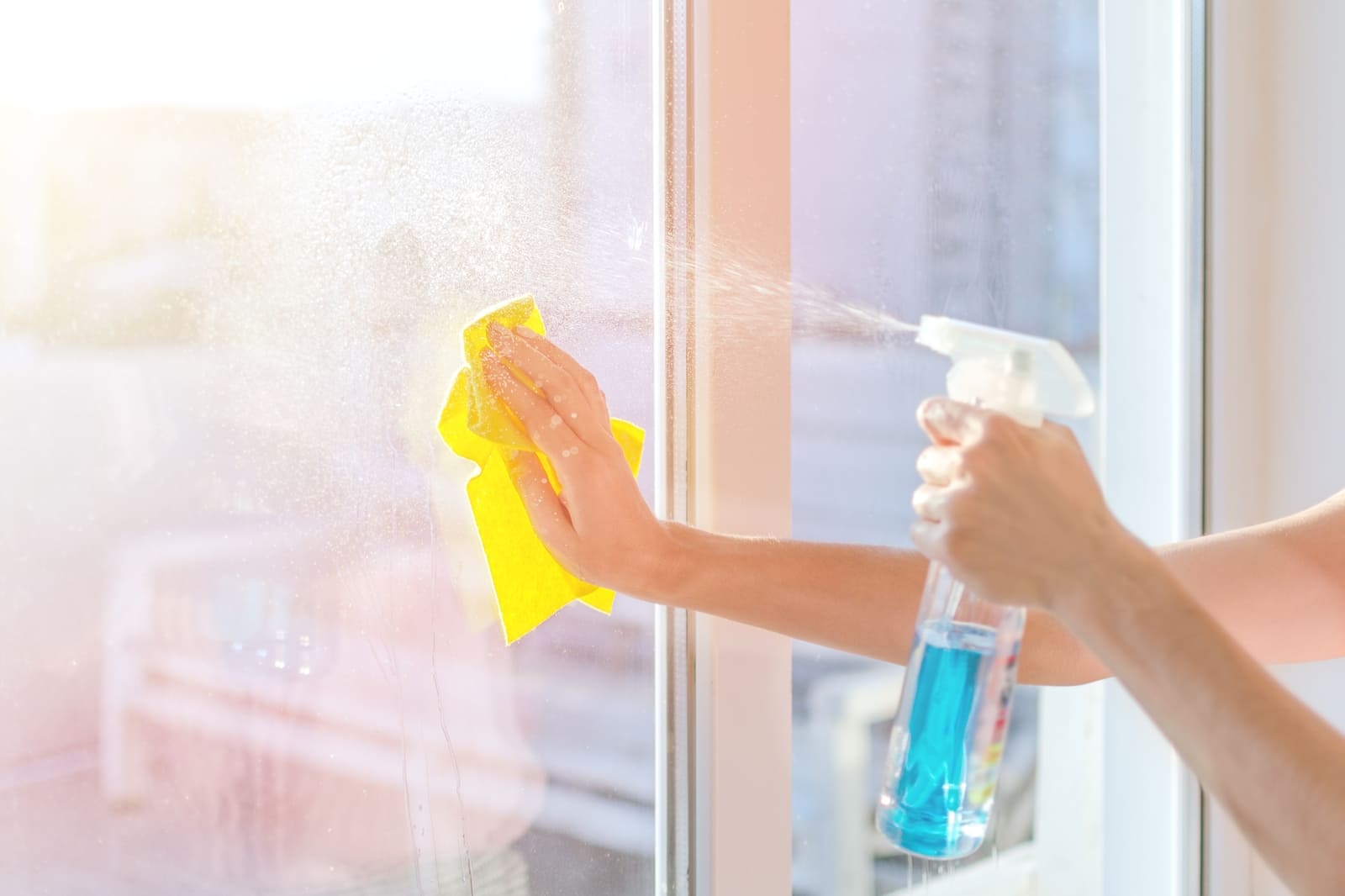 hands with napkin cleaning window